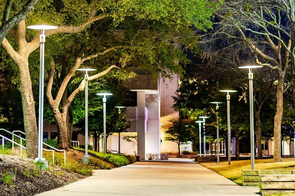 A campus walkway at night.
