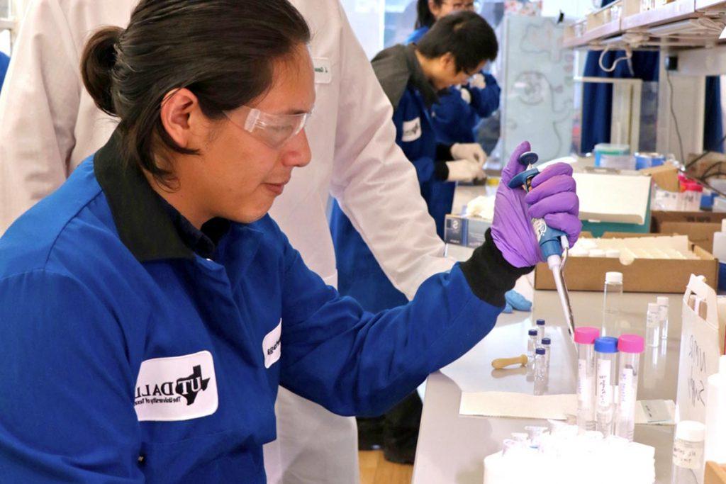 A researcher uses a liquid dropper in a laboratory. 