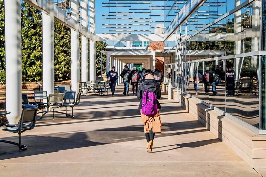Students walk past the Student Services Building on campus.
